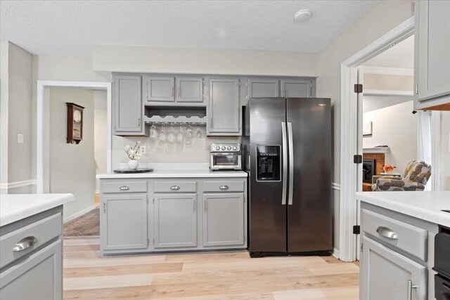 3077 Stonecrest Cir E, Lakeland, TN 38002 - kitchen with stainless steel refrigerator with ice dispenser, gray cabinets, light wood-style floors, light countertops, and a textured ceiling