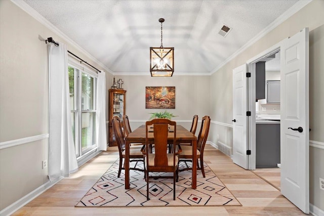 3077 Stonecrest Cir E, Lakeland, TN 38002 - dining area with light wood finished floors, a chandelier, crown molding, and a textured ceiling