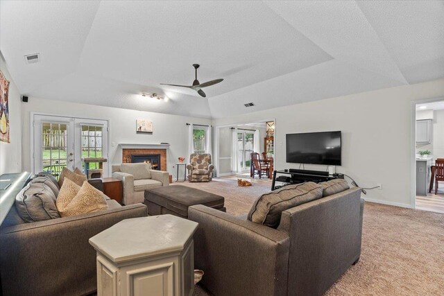3077 Stonecrest Cir E, Lakeland, TN 38002 - living area with a raised ceiling, light colored carpet, a ceiling fan, french doors, and a glass covered fireplace