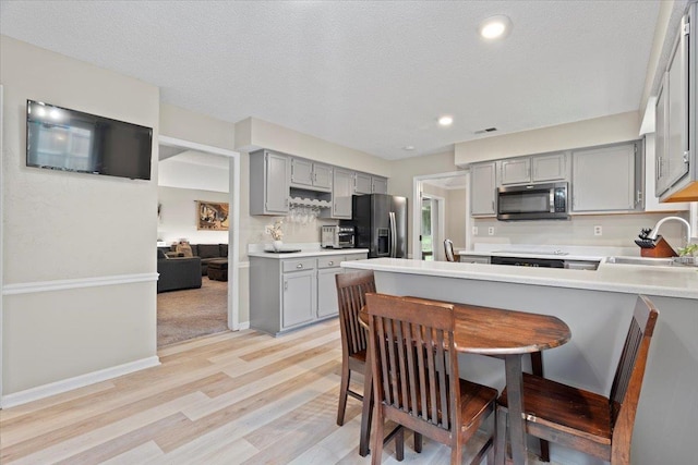 3077 Stonecrest Cir E, Lakeland, TN 38002 - kitchen with gray cabinetry, stainless steel microwave, refrigerator with ice dispenser, light wood-type flooring, and recessed lighting