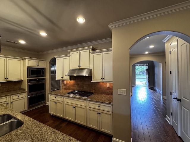 10040 Dropseed Cir, Lakeland, TN 38002 - kitchen with under cabinet range hood, arched walkways, appliances with stainless steel finishes, stone countertops, and ornamental molding