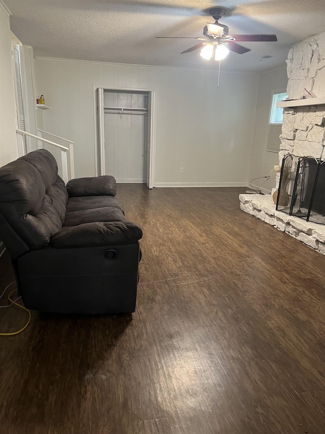 3603 Bigelow St, Memphis, TN 38127 - living room with a textured ceiling, ceiling fan, wood finished floors, and a stone fireplace