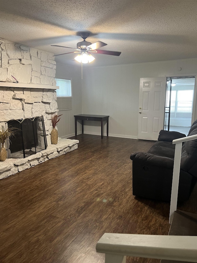 3603 Bigelow St, Memphis, TN 38127 - living area with a textured ceiling, ceiling fan, wood finished floors, and a stone fireplace