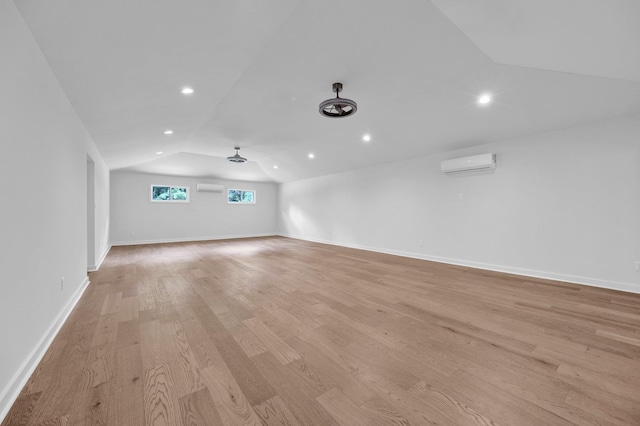 9700 N Helene Cv, Millington, TN 38053 - spare room featuring vaulted ceiling, a wall mounted AC, light wood-type flooring, and recessed lighting