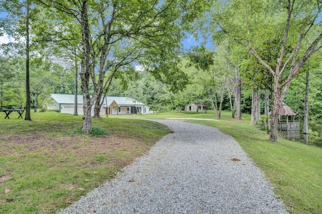 9700 N Helene Cv, Millington, TN 38053 - view of property's community with a lawn, gravel driveway, and view of wooded area