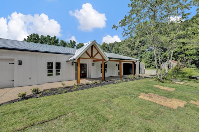 9700 N Helene Cv, Millington, TN 38053 - modern farmhouse style home with board and batten siding, a front lawn, an attached garage, and a metal roof
