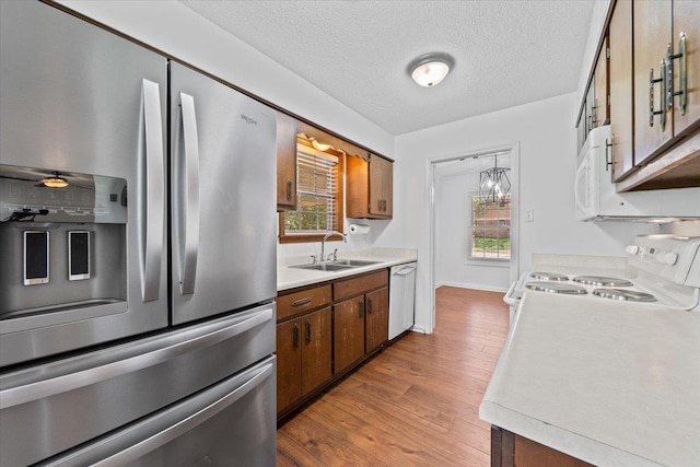 6864 Aspenhill Dr, Bartlett, TN 38135 - kitchen with white appliances, light countertops, light wood finished floors, brown cabinets, and a textured ceiling