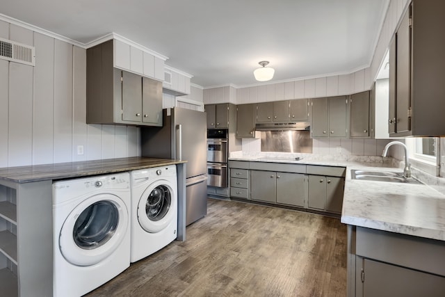 3218 Joffre Ave, Memphis, TN 38111 - kitchen with washing machine and clothes dryer, gray cabinets, stainless steel double oven, dark wood-style flooring, and ornamental molding