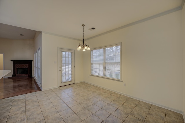 6384 Acree Woods Dr, Olive Branch, MS 38654 - unfurnished dining area featuring a fireplace, a chandelier, crown molding, and light tile patterned floors