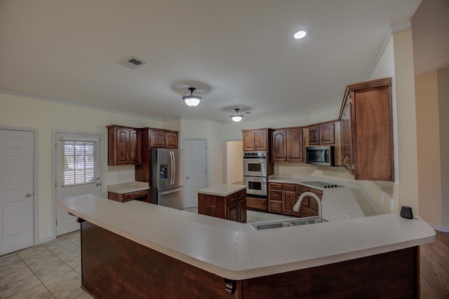 6384 Acree Woods Dr, Olive Branch, MS 38654 - kitchen featuring appliances with stainless steel finishes, light countertops, crown molding, a peninsula, and a kitchen island