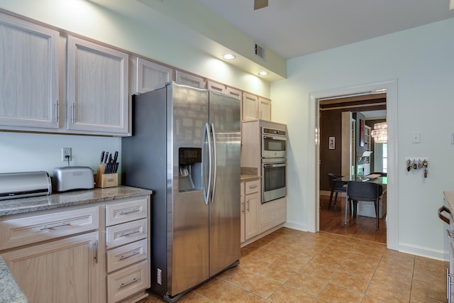 1501 Granville Ln, Memphis, TN 38104 - kitchen with appliances with stainless steel finishes, light stone countertops, and light tile patterned flooring