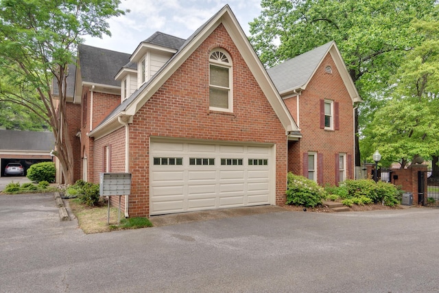 1501 Granville Ln, Memphis, TN 38104 - traditional-style house featuring driveway, brick siding, roof with shingles, and a garage