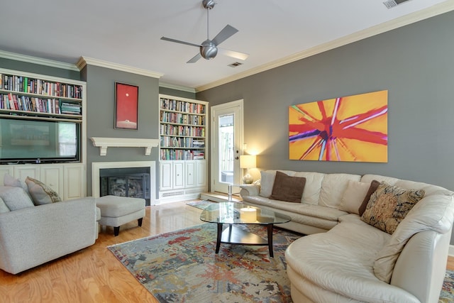 1501 Granville Ln, Memphis, TN 38104 - living room with wood finished floors, a ceiling fan, ornamental molding, a fireplace, and built in shelves