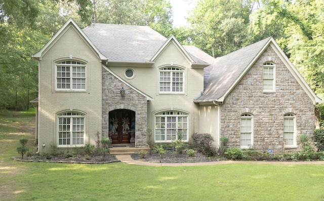 11095 Latting Rd, Eads, TN 38028 - french country home with stone siding, a front yard, a shingled roof, and brick siding