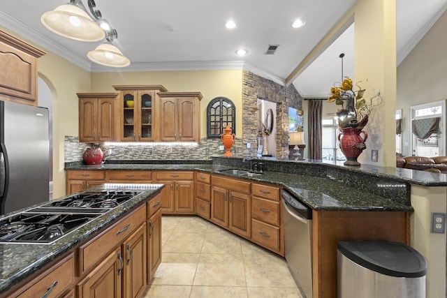 11095 Latting Rd, Eads, TN 38028 - kitchen featuring appliances with stainless steel finishes, ornamental molding, glass insert cabinets, brown cabinetry, and decorative backsplash