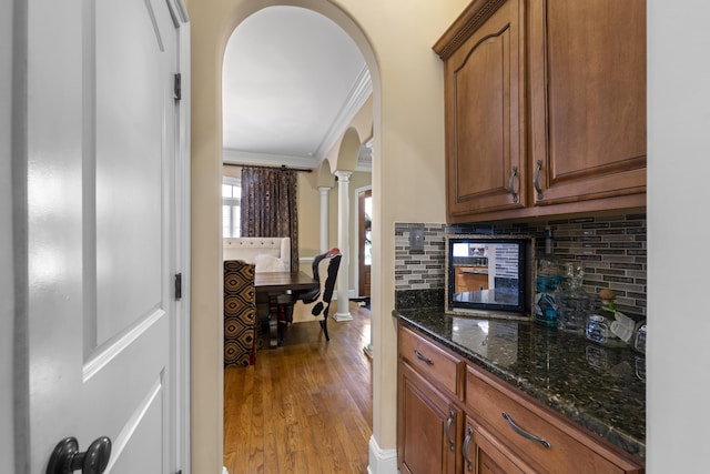 11095 Latting Rd, Eads, TN 38028 - kitchen featuring arched walkways, ornate columns, tasteful backsplash, dark stone counters, and light wood-type flooring