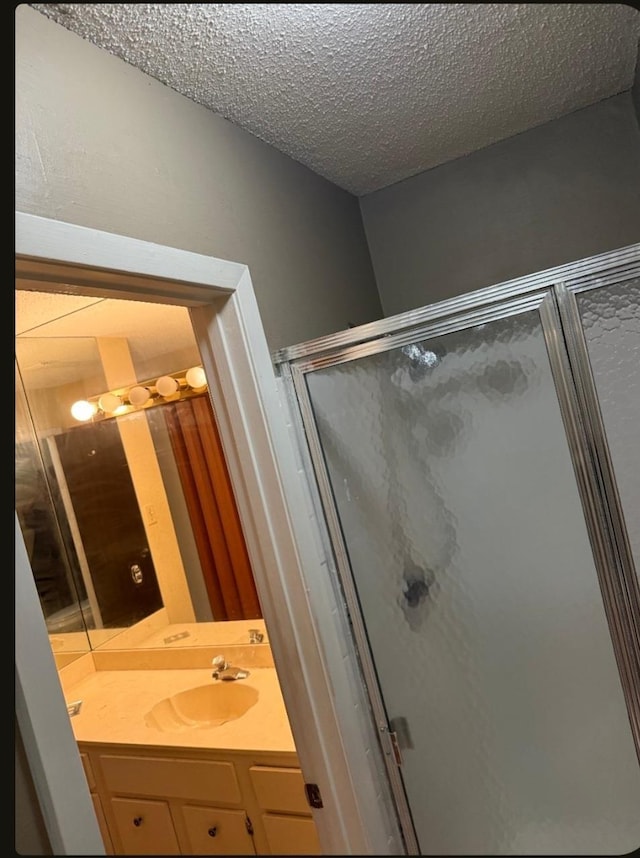 4779 Towering Oaks Dr Unit 704, Memphis, TN 38117 - bathroom with a shower stall, vanity, and a textured ceiling