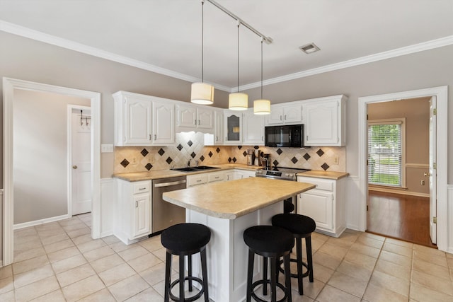 1231 Pinnacle Point Dr, Collierville, TN 38017 - kitchen featuring stainless steel appliances, light tile patterned flooring, rail lighting, light countertops, and crown molding