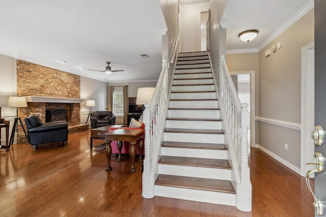 1231 Pinnacle Point Dr, Collierville, TN 38017 - stairway featuring ornamental molding, a ceiling fan, wood finished floors, and a brick fireplace