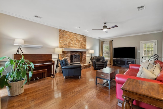 1231 Pinnacle Point Dr, Collierville, TN 38017 - living area featuring a brick fireplace, plenty of natural light, wood finished floors, a ceiling fan, and crown molding
