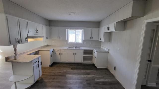3499 Rockwood Ave, Memphis, TN 38122 - kitchen featuring under cabinet range hood, dark wood-type flooring, open shelves, white cabinetry, and light countertops