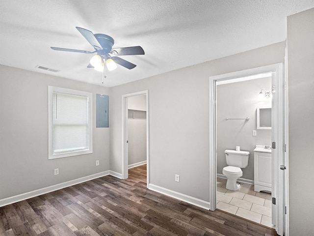 1644 N Graham St, Memphis, TN 38108 - unfurnished bedroom featuring wood finished floors, a walk in closet, ensuite bath, a ceiling fan, and a closet