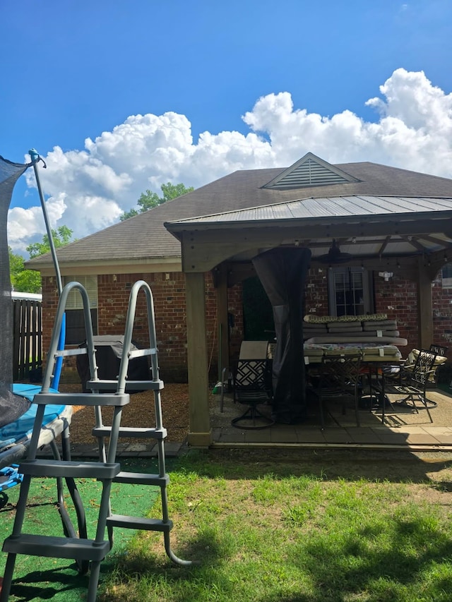 4568 Perkins Grove Cv, Memphis, TN 38122 - rear view of house with brick siding, a gazebo, a patio area, and a yard