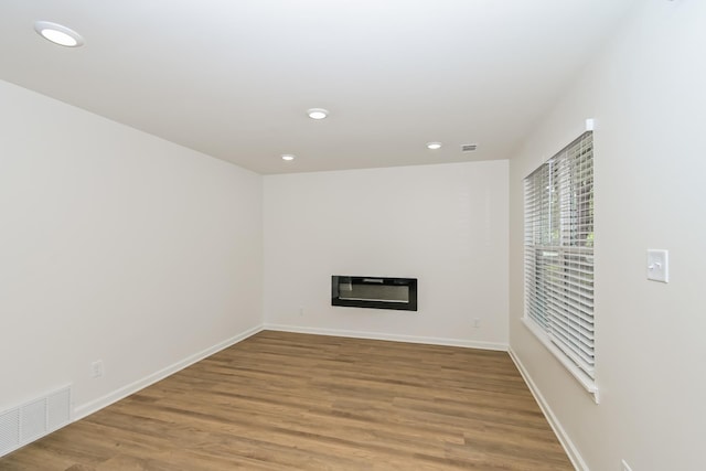 4130 Cottonwood Rd, Memphis, TN 38118 - unfurnished living room featuring a glass covered fireplace, recessed lighting, and light wood-type flooring