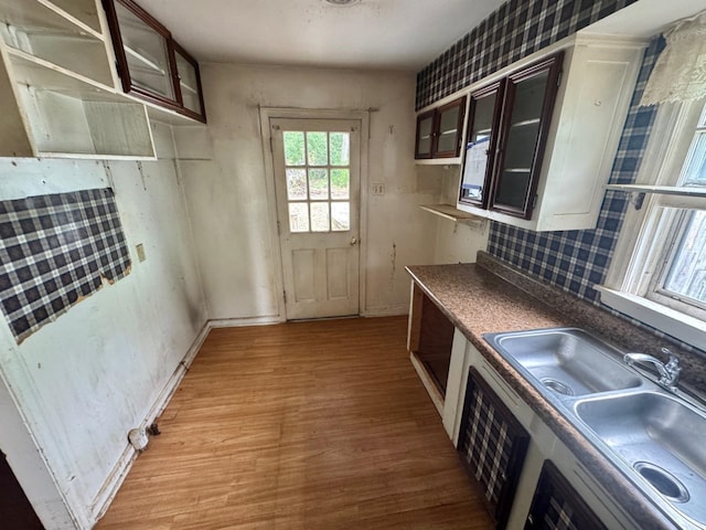1445 Depass St, Memphis, TN 38122 - kitchen with light wood finished floors, glass insert cabinets, and backsplash