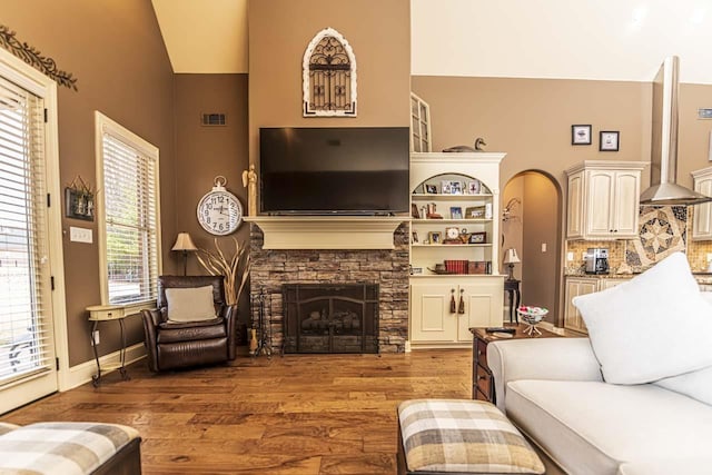 190 Links View Dr, Oakland, TN 38060 - living area featuring hardwood / wood-style flooring, a stone fireplace, high vaulted ceiling, and arched walkways
