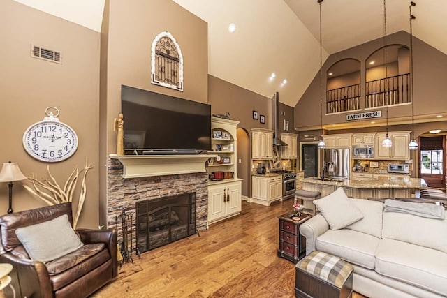 190 Links View Dr, Oakland, TN 38060 - living area with high vaulted ceiling, wood finished floors, a stone fireplace, and arched walkways
