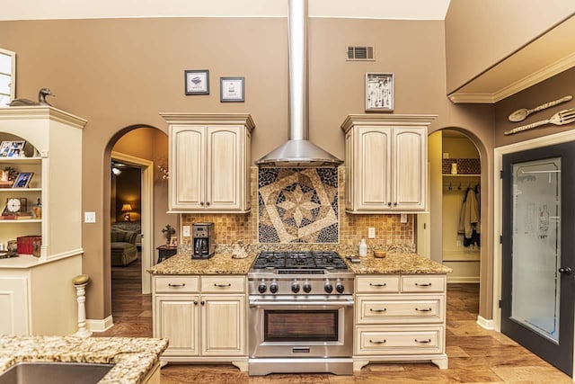 190 Links View Dr, Oakland, TN 38060 - kitchen featuring stainless steel stove, arched walkways, cream cabinetry, and light stone counters