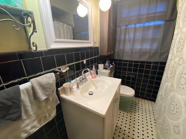 4643 E Renshaw Dr, Memphis, TN 38122 - full bathroom with vanity, tile walls, and a shower with shower curtain