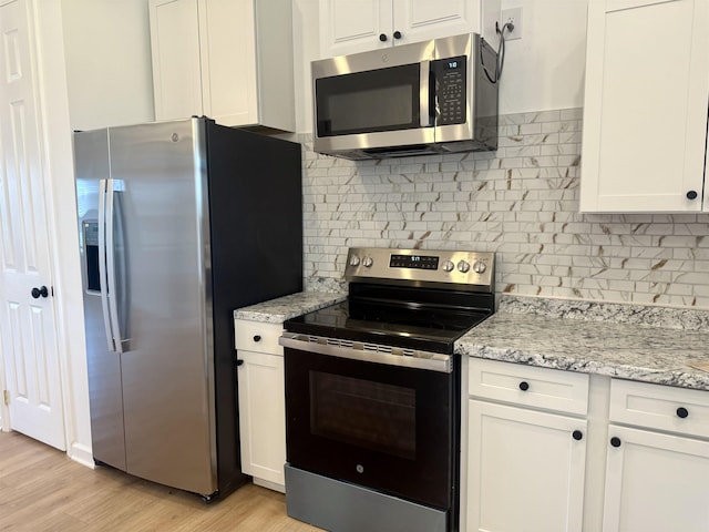 32 Foxchase Dr, Mason, TN 38049 - kitchen with stainless steel appliances, white cabinetry, backsplash, and light wood-style flooring