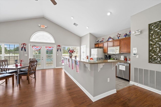 8897 Parkview Oaks Cir, Olive Branch, MS 38654 - kitchen with white appliances, a kitchen breakfast bar, brown cabinetry, ceiling fan, and wood finished floors