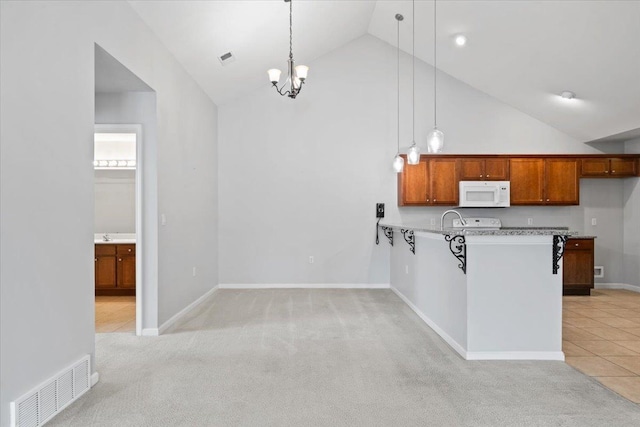 8897 Parkview Oaks Cir, Olive Branch, MS 38654 - kitchen with white microwave, high vaulted ceiling, light carpet, light countertops, and decorative light fixtures