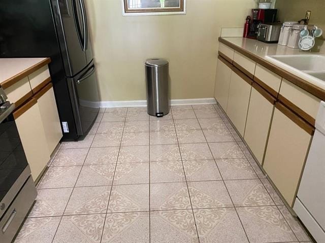7148 Tranquil Creek Dr, Memphis, TN 38125 - kitchen featuring light tile patterned flooring, light countertops, white cabinets, stainless steel stove, and freestanding refrigerator