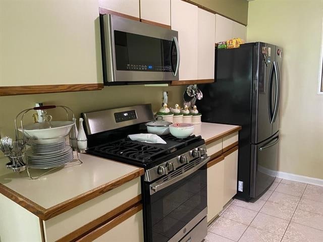 7148 Tranquil Creek Dr, Memphis, TN 38125 - kitchen featuring stainless steel appliances, white cabinets, light countertops, and light tile patterned floors