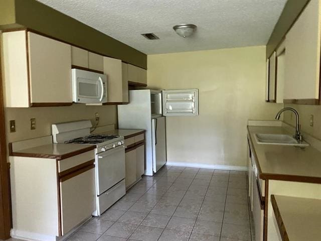 7148 Tranquil Creek Dr, Memphis, TN 38125 - kitchen featuring white appliances, a textured ceiling, white cabinets, and light tile patterned flooring