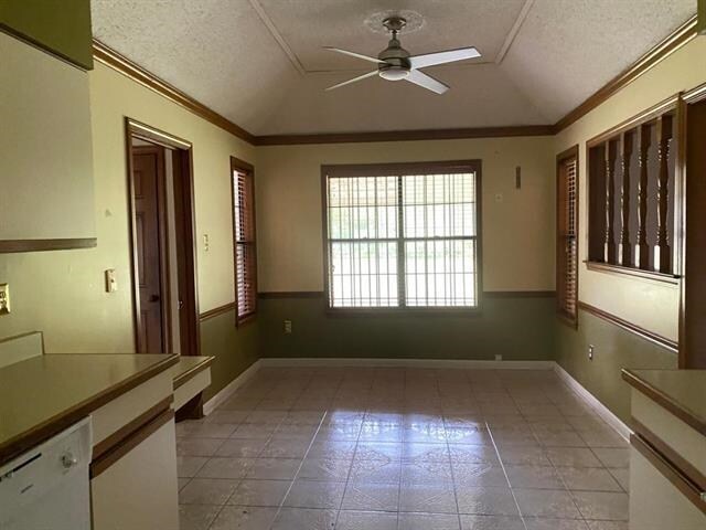 7148 Tranquil Creek Dr, Memphis, TN 38125 - unfurnished dining area featuring a ceiling fan, a textured ceiling, lofted ceiling, crown molding, and light tile patterned floors