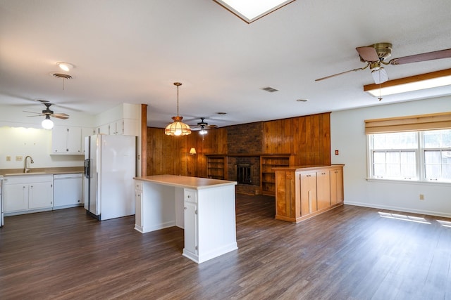 5662 Chapman Ave, Memphis, TN 38119 - kitchen featuring white appliances, ceiling fan, wood walls, open floor plan, and a kitchen island