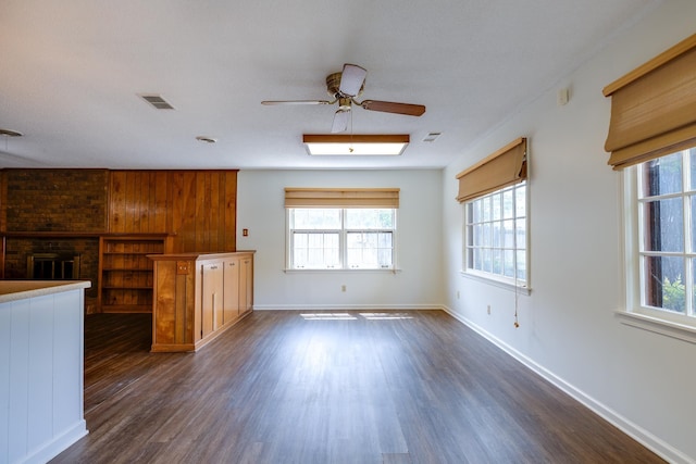 5662 Chapman Ave, Memphis, TN 38119 - unfurnished living room with healthy amount of natural light, dark wood-style floors, a ceiling fan, and wooden walls