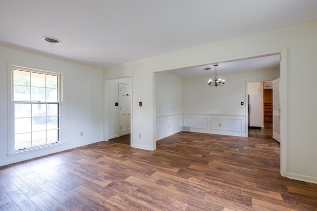 5662 Chapman Ave, Memphis, TN 38119 - empty room with a chandelier, wood finished floors, crown molding, wainscoting, and a decorative wall