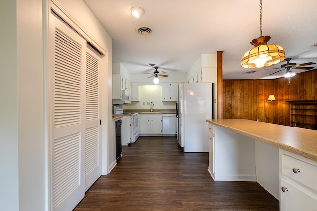 5662 Chapman Ave, Memphis, TN 38119 - kitchen with white appliances, ceiling fan, dark wood-type flooring, white cabinetry, and wooden walls