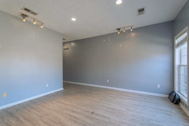 119 N 4th St, Selmer, TN 38375 - spare room featuring rail lighting, healthy amount of natural light, wood finished floors, and recessed lighting
