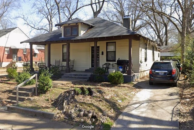 776 Pope St, Memphis, TN 38112 - view of front of house featuring a chimney, covered porch, and concrete driveway