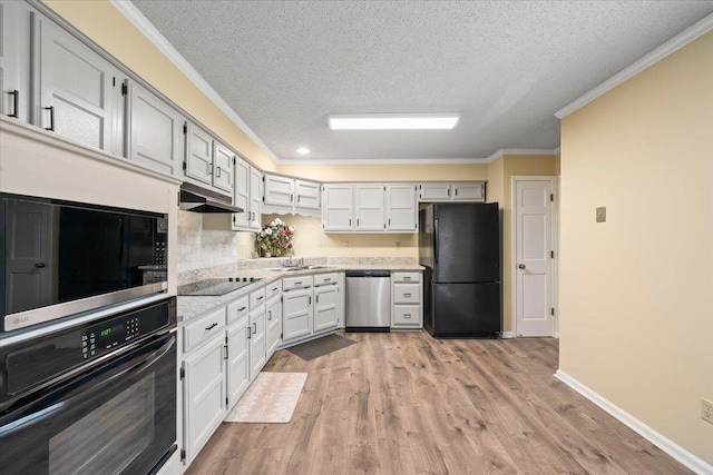 3889 Oak Trace Cv, Bartlett, TN 38135 - kitchen with black appliances, a textured ceiling, ornamental molding, light wood-style flooring, and under cabinet range hood