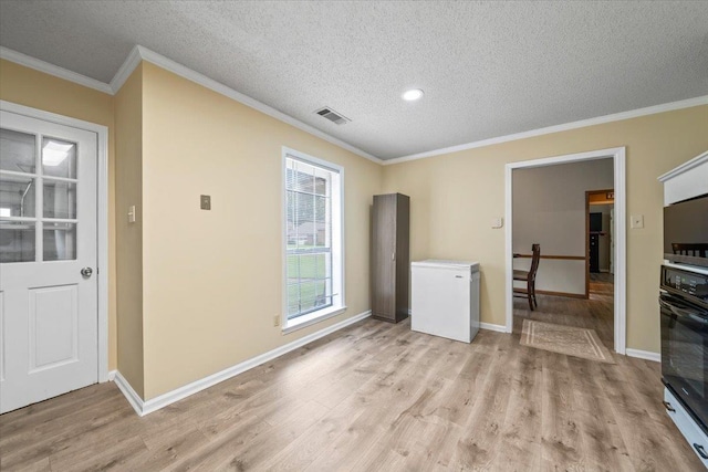 3889 Oak Trace Cv, Bartlett, TN 38135 - unfurnished living room with a textured ceiling, light wood-style flooring, and crown molding