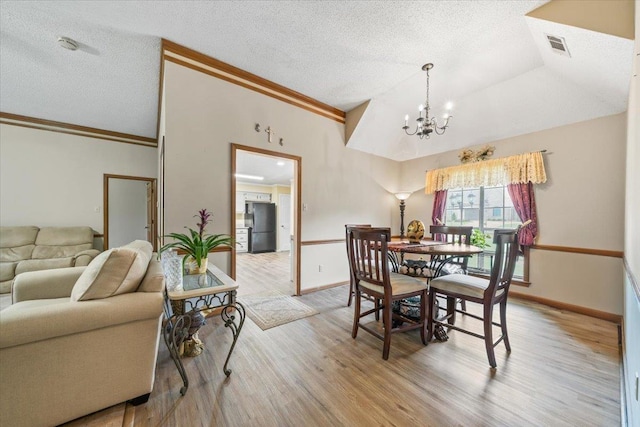 3889 Oak Trace Cv, Bartlett, TN 38135 - dining area featuring a chandelier, wood finished floors, a textured ceiling, and crown molding