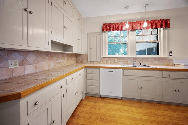 2067 Hallwood Dr, Memphis, TN 38107 - kitchen with dishwasher, tile countertops, decorative light fixtures, decorative backsplash, and light wood finished floors